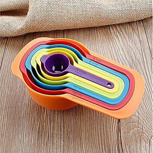 Set of colorful measuring cups and spoons on a wooden surface