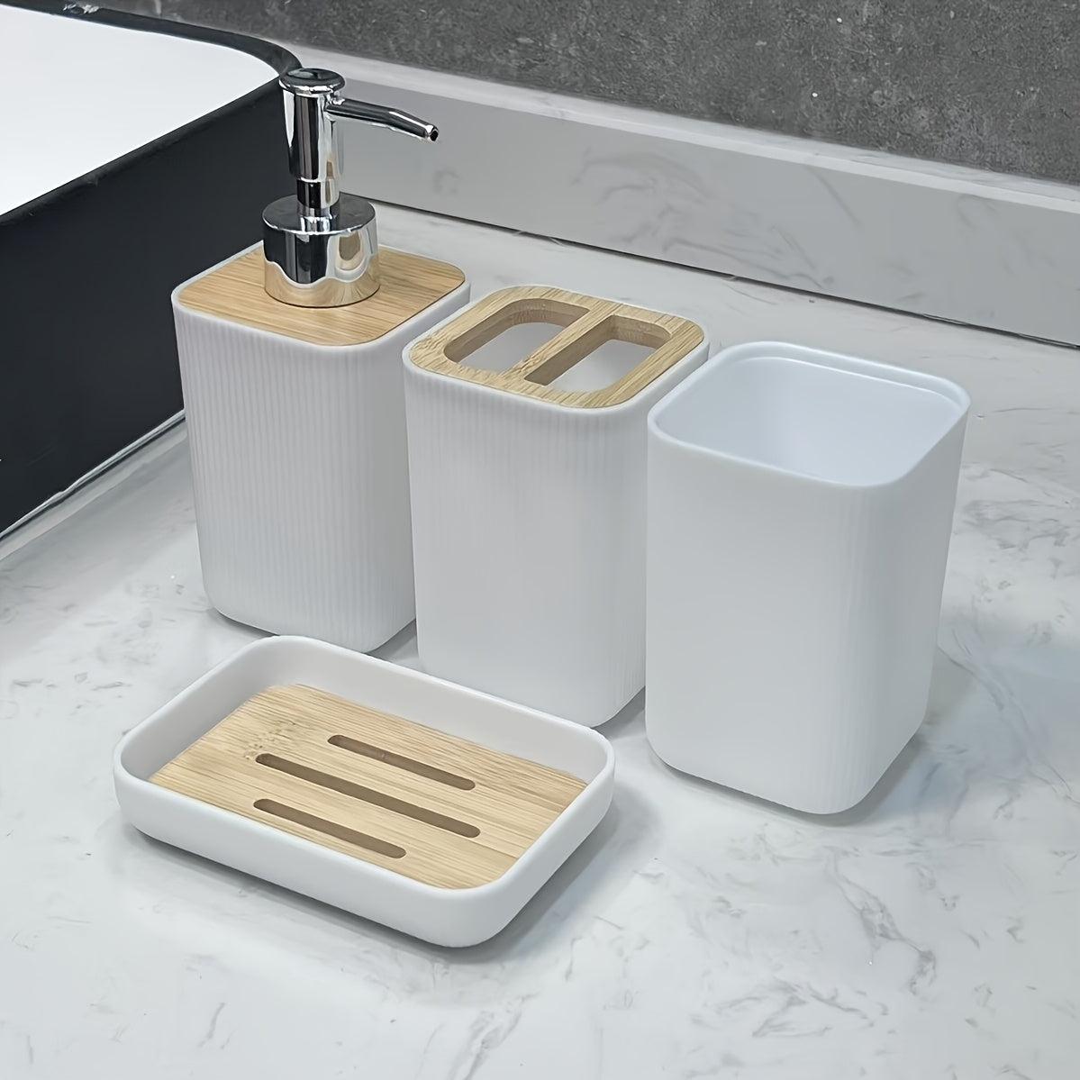 Bathroom accessory set with white containers and wooden accents on a marble countertop.
