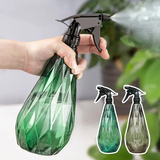 Hand holding a green spray bottle with a detailed design, with two additional spray bottles shown below.