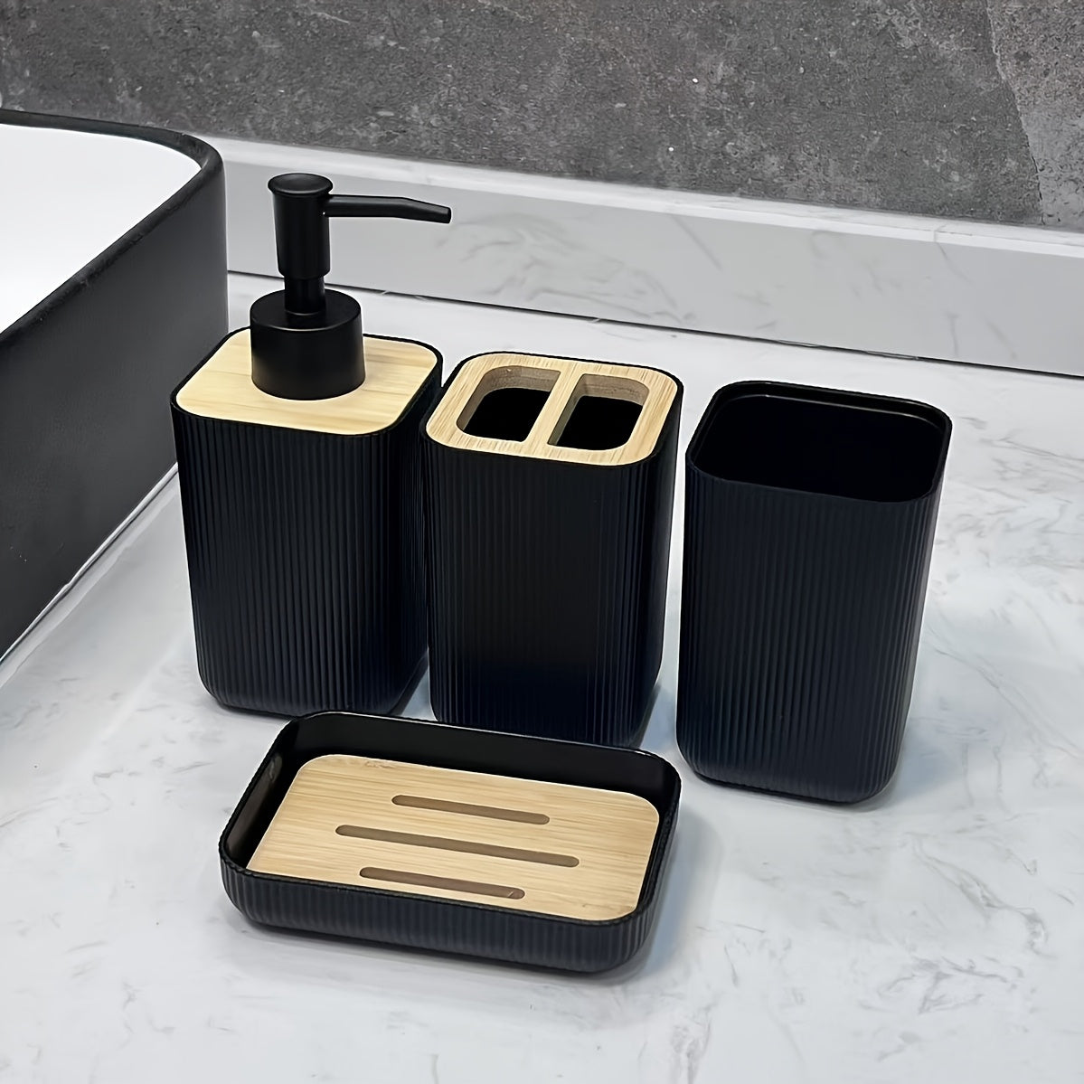 Bathroom accessory set with black and wooden elements on a marble surface.