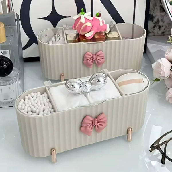 Two beige storage baskets with decorative bows on a white surface.