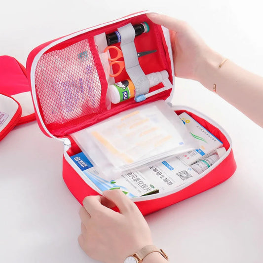 Red first aid kit with various supplies on a white background