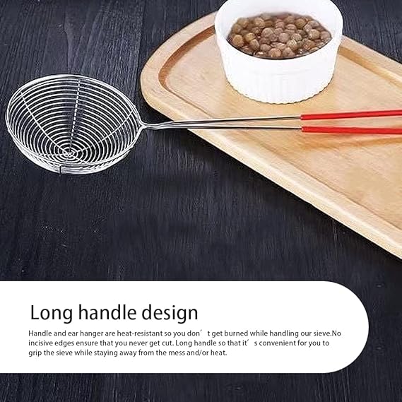 Metal sieve with long handle on a wooden tray with a bowl of food