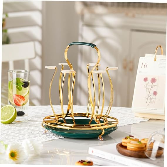 Gold and green dish drying rack on a kitchen counter with a glass of water and lime.