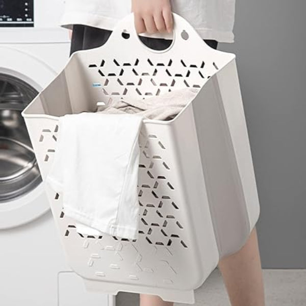Person holding a white laundry basket with geometric patterns in front of a washing machine.