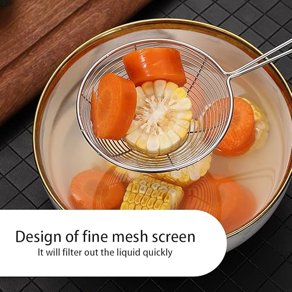 Metallic fine mesh screen with sliced carrots and corn in a bowl on a dark tiled background.