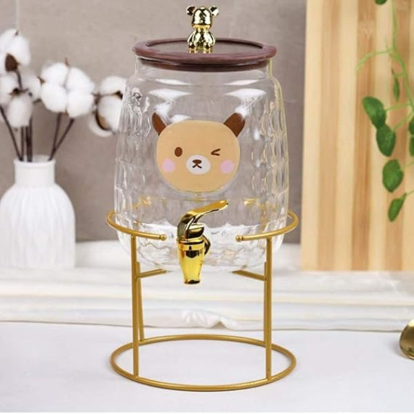 Decorative glass container with cartoon face design on a stand, featuring a gold faucet.