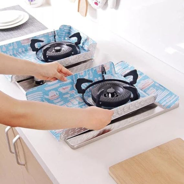 Person holding a portable gas stove with a blue flame design on a white surface.
