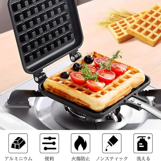 Waffle maker with a waffle topped with tomatoes and greens on a wooden table.