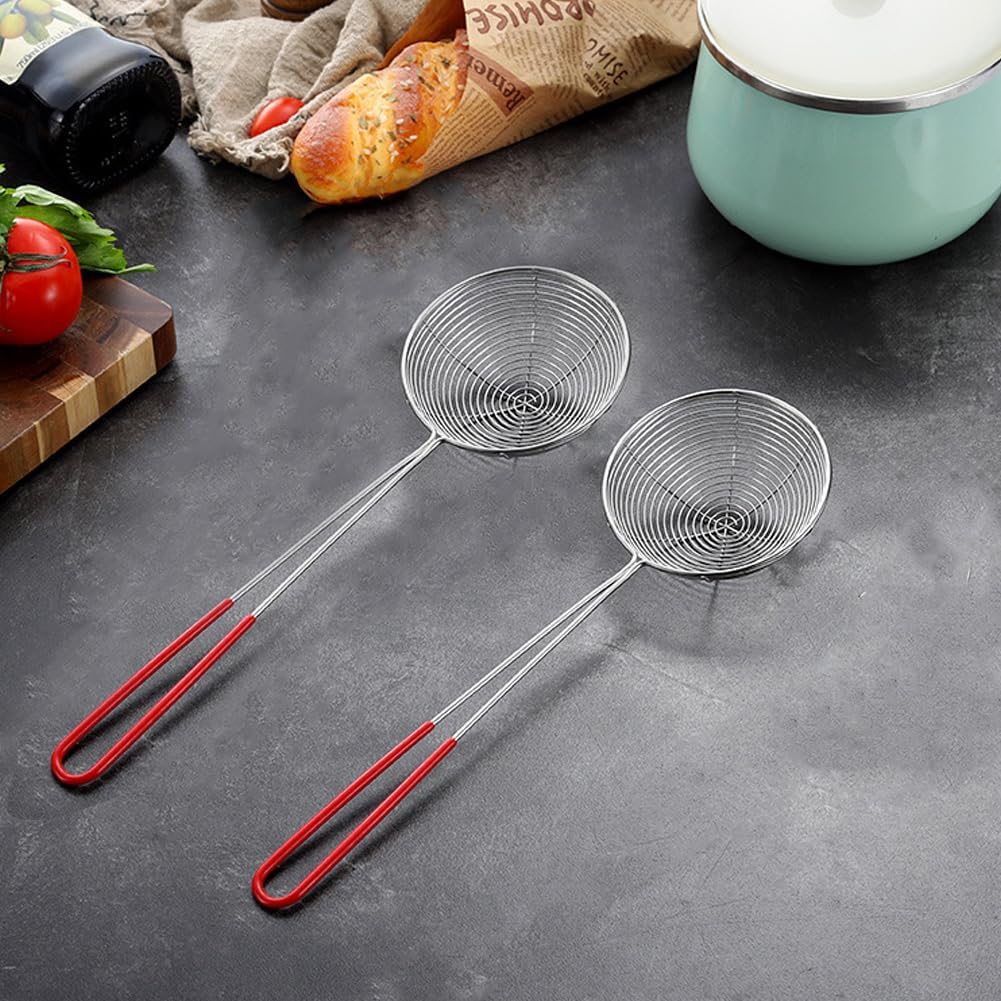 Two metal strainers with red handles on a dark surface with kitchen items in the background.