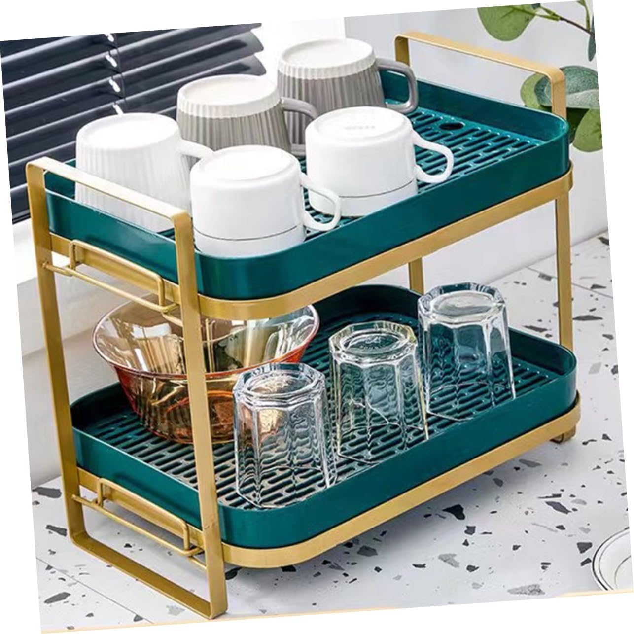 Two-tiered dish rack with cups and glasses on a marble surface