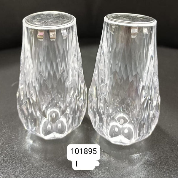 Two clear glass salt and pepper shakers on a dark surface with a label '101895'.