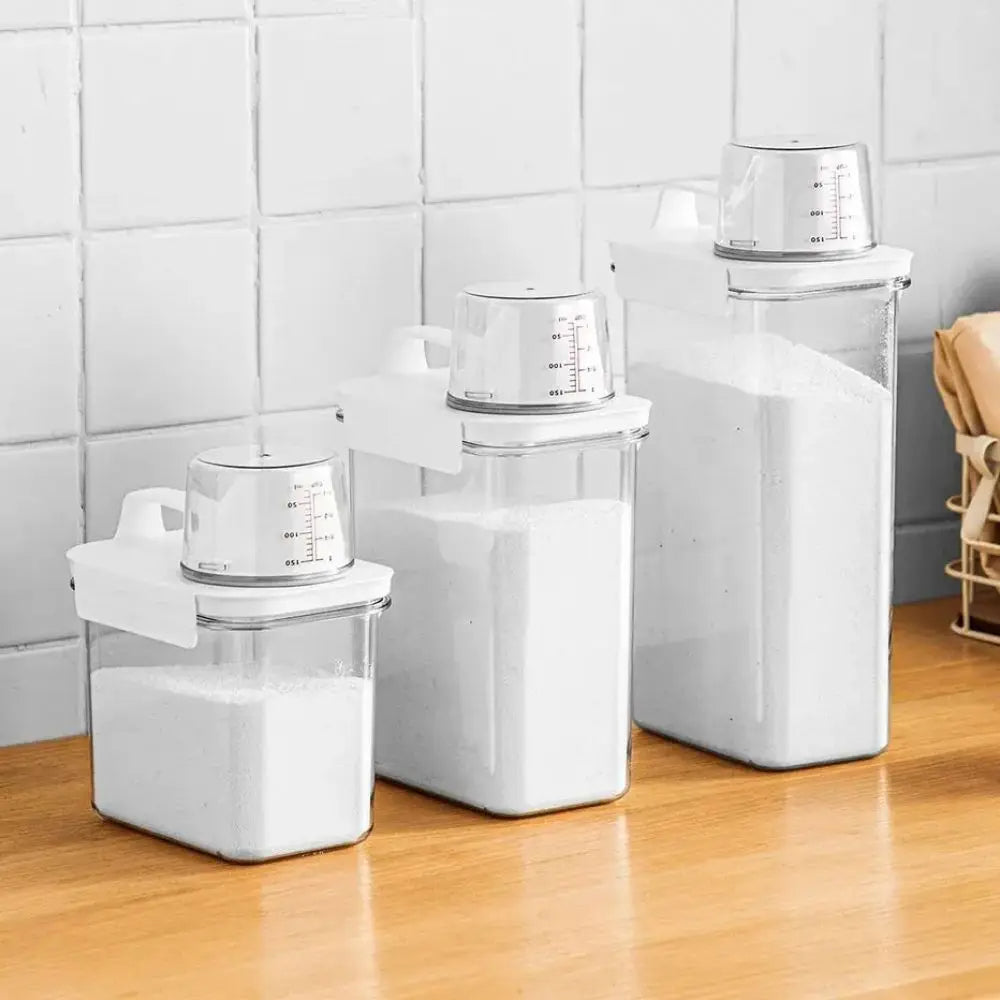Set of white kitchen containers with measuring cups on a wooden surface.