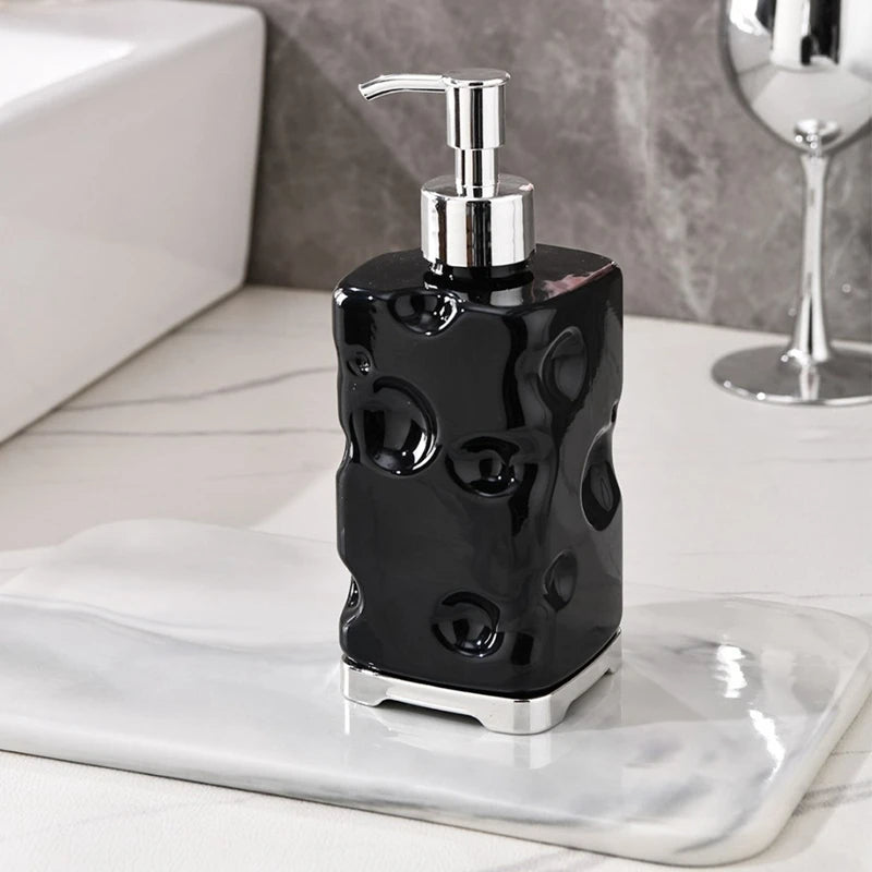 Black soap dispenser with silver pump on a marble surface