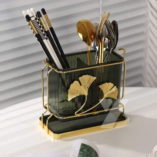 Decorative pen holder with gold accents and ginkgo leaf designs on a neutral background