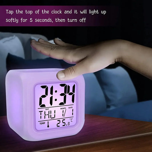 Digital clock with LED display on a wooden surface, showing time and date.