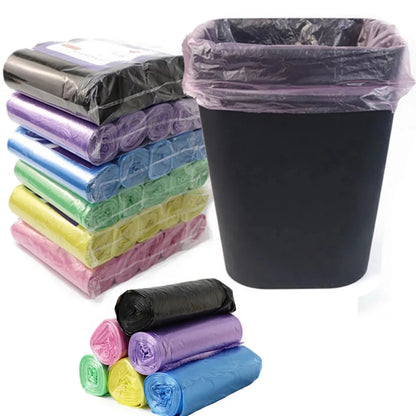 Assorted colored trash bags in rolls with a black trash bin.