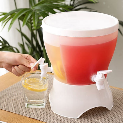 White drink dispenser with red and orange liquid, being used to pour into a glass on a table.
