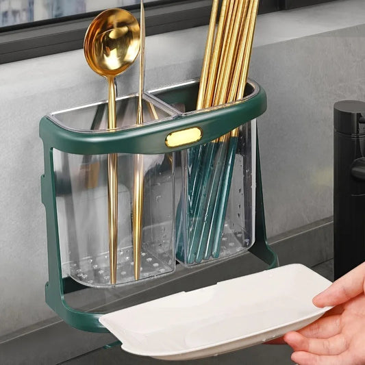 Dish drying rack with gold spoons and green ladle, held by a hand.