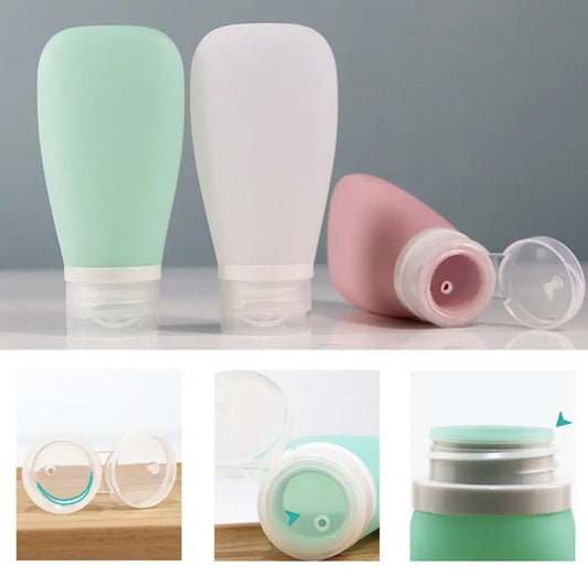 Set of three silicone bottles in green, white, and pink with various components on a gray background.