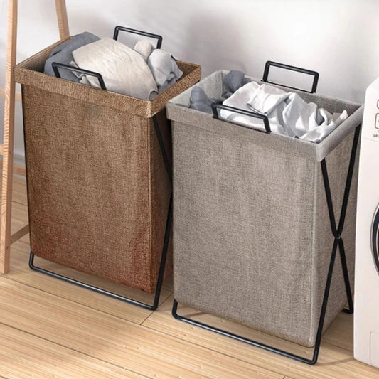 Two laundry baskets with clothes on a wooden floor next to a washing machine.
