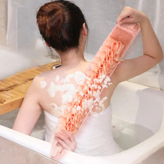 Person in a bathtub with a bath brush, surrounded by bubbles