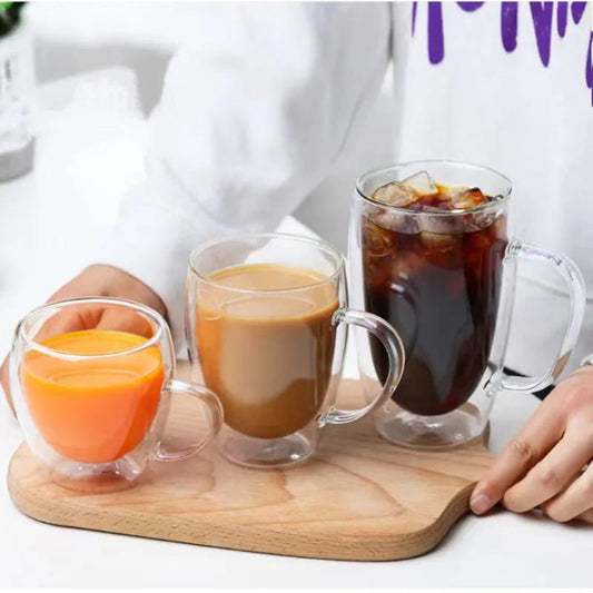 Four glass cups with different beverages on a wooden tray.