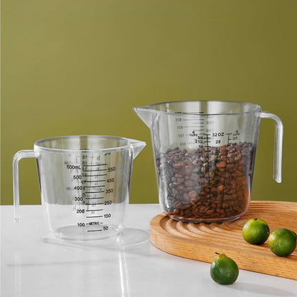 Two clear measuring cups with coffee beans and limes on a wooden board against a green background
