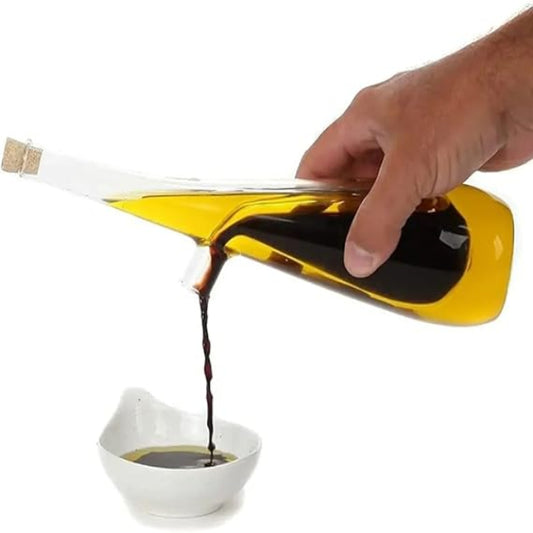 Hand pouring dark liquid from a yellow bottle into a white bowl on a white background
