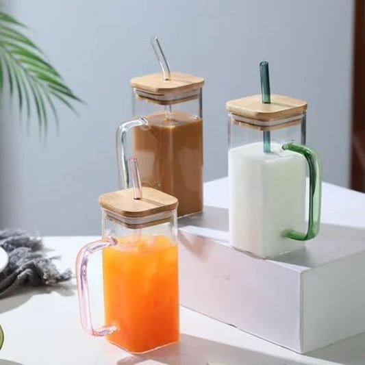 Set of glass mugs with wooden lids and straws containing different beverages on a white surface.