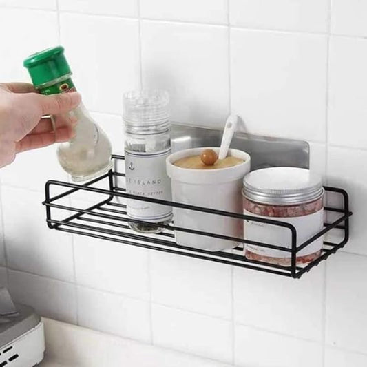 Black wall-mounted shelf with various containers on a tiled wall background