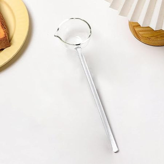 Silver ladle on a white surface with a blurred background