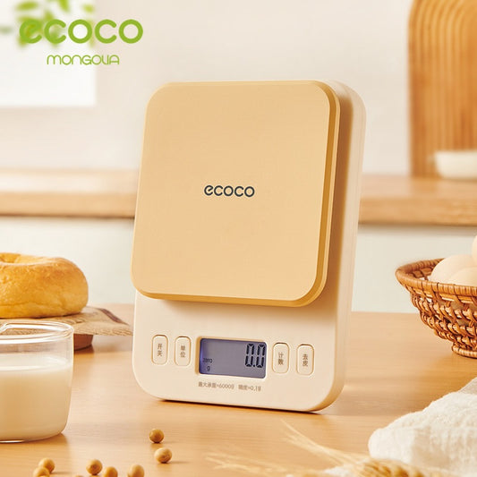 Digital kitchen scale with 'ecoco' branding on a wooden surface with food items.