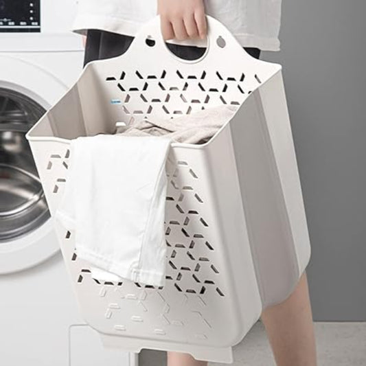 Person holding a white laundry basket with geometric patterns in front of a washing machine.