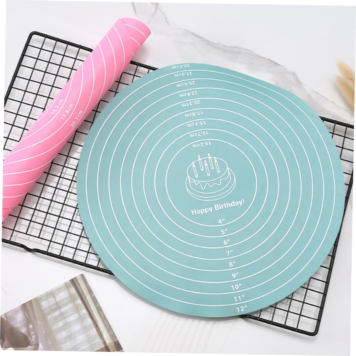 Teal silicone baking mat with measurement markings on a cooling rack