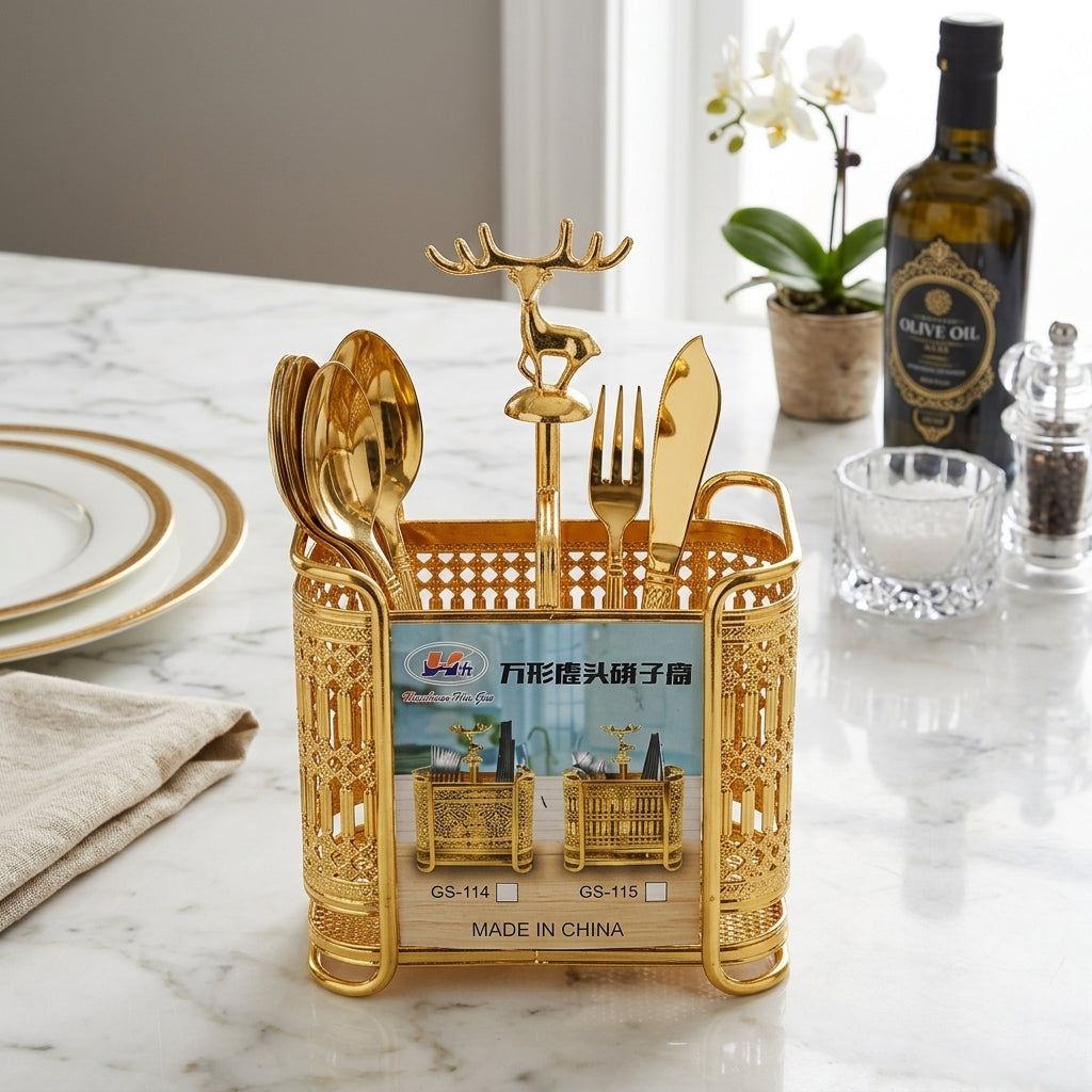 Gold cutlery holder with utensils on a marble surface with a bottle and plant in the background