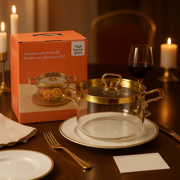 Clear glass pot with gold handle on a table with a box and candles in the background