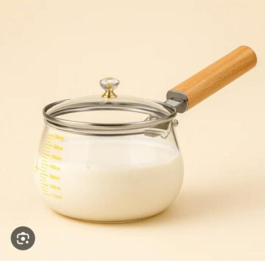 Glass jar with wooden handle and metal lid on a beige background