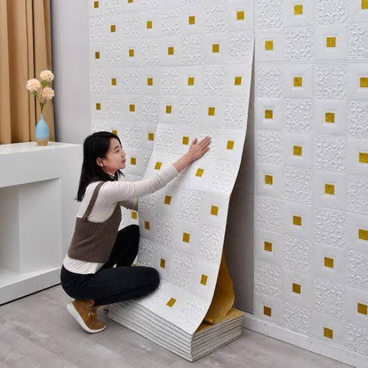 Woman unrolling decorative wallpaper with a gold and white pattern.