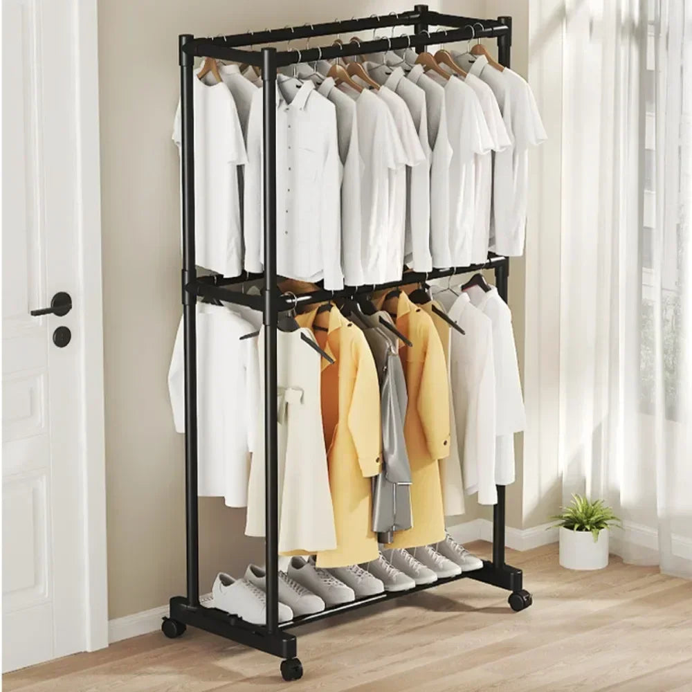 Clothing rack with clothes and shoes on a wooden floor.