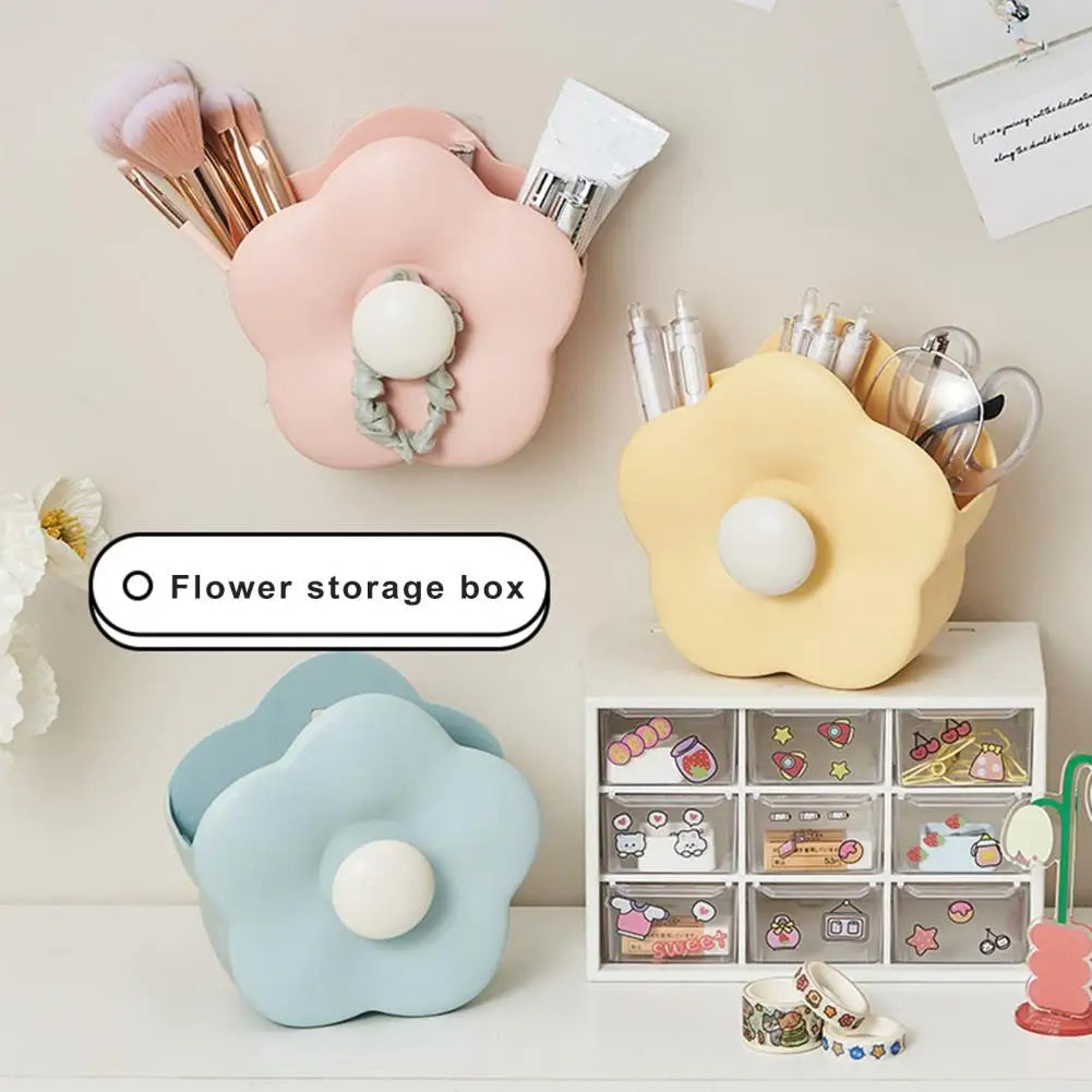 Flower-shaped storage boxes in pink, yellow, and blue on a desk with stationery items.