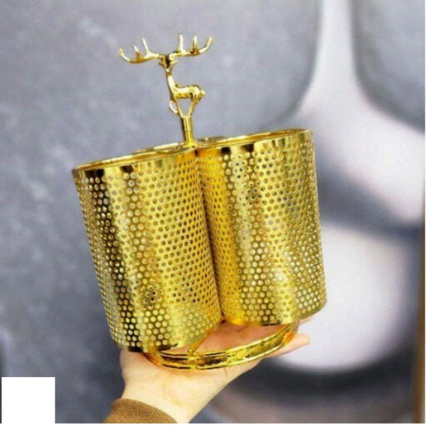 Gold deer-shaped cup holder with honeycomb design held by a hand against a gray background